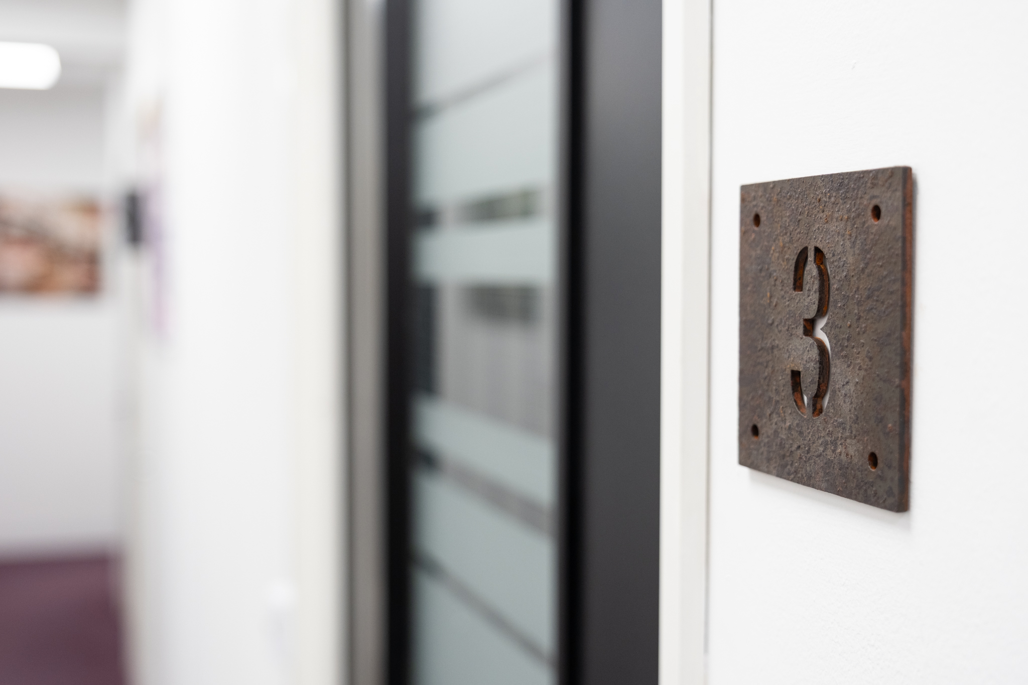 Close up on door sign number for office 3, 4 Tannery House with corridor in background