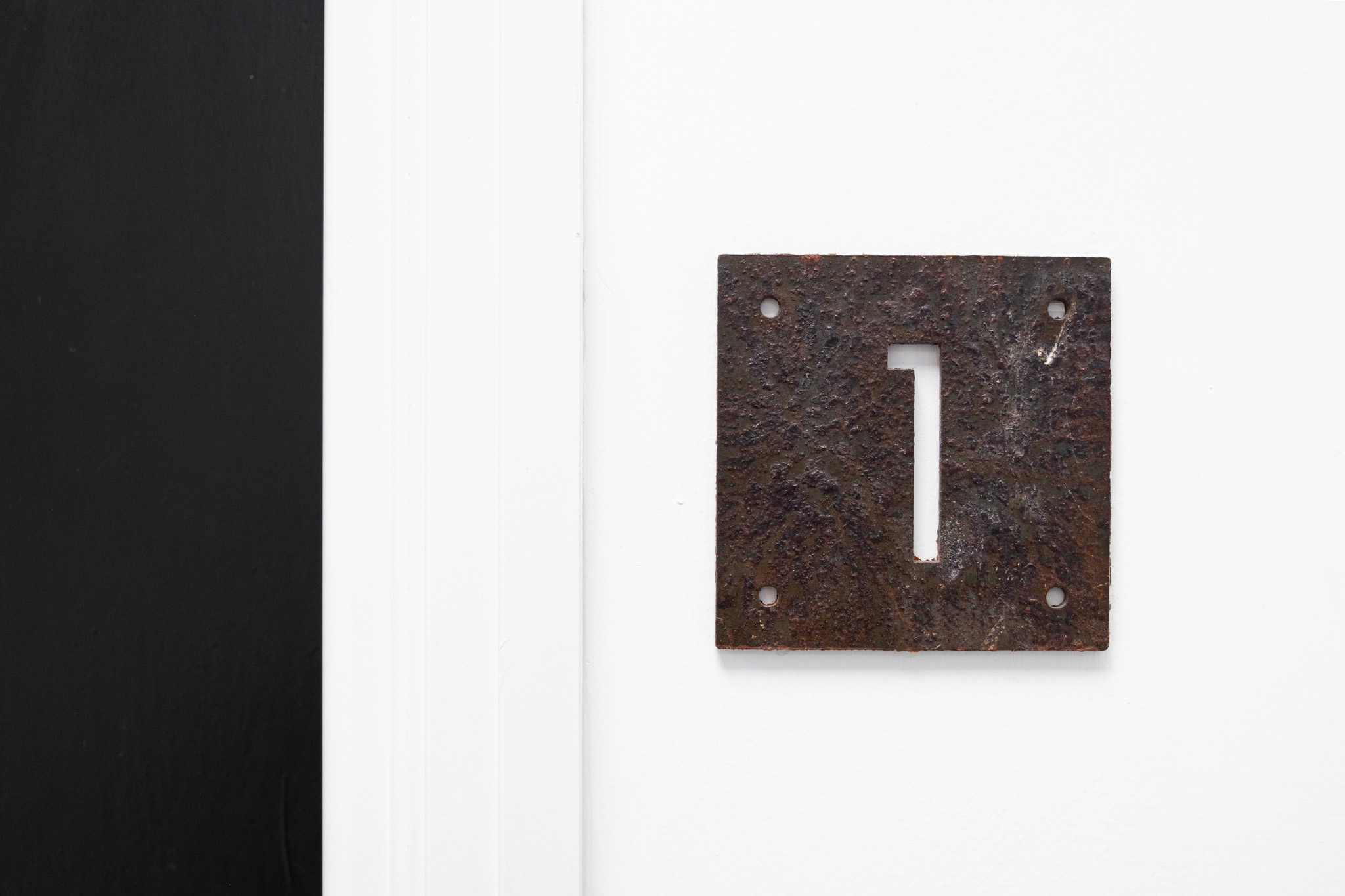 Close up on door sign number for office 1, 4 Tannery House with corridor in background