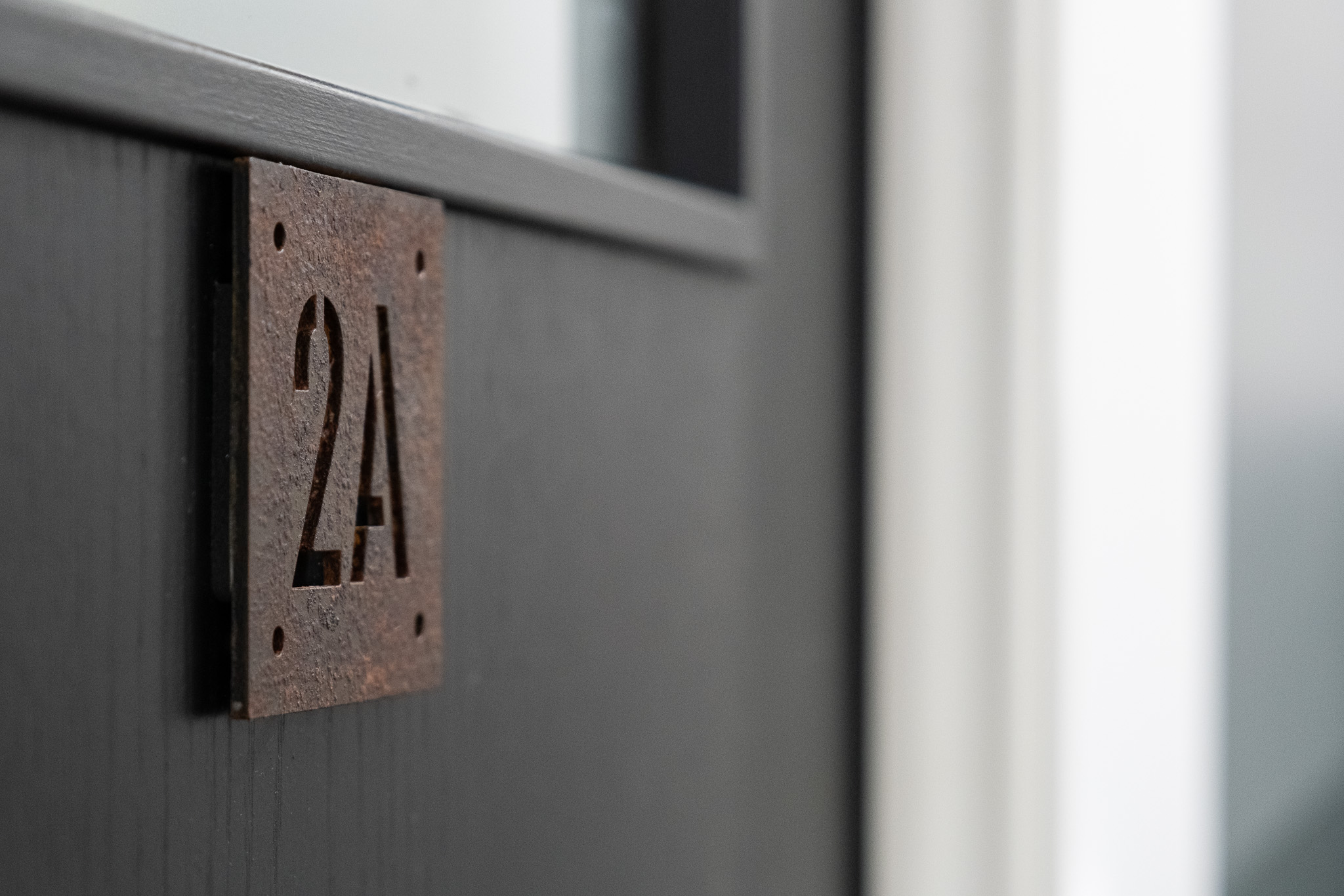 Close up on door sign number for office 2A, 3 Tannery House with corridor in background