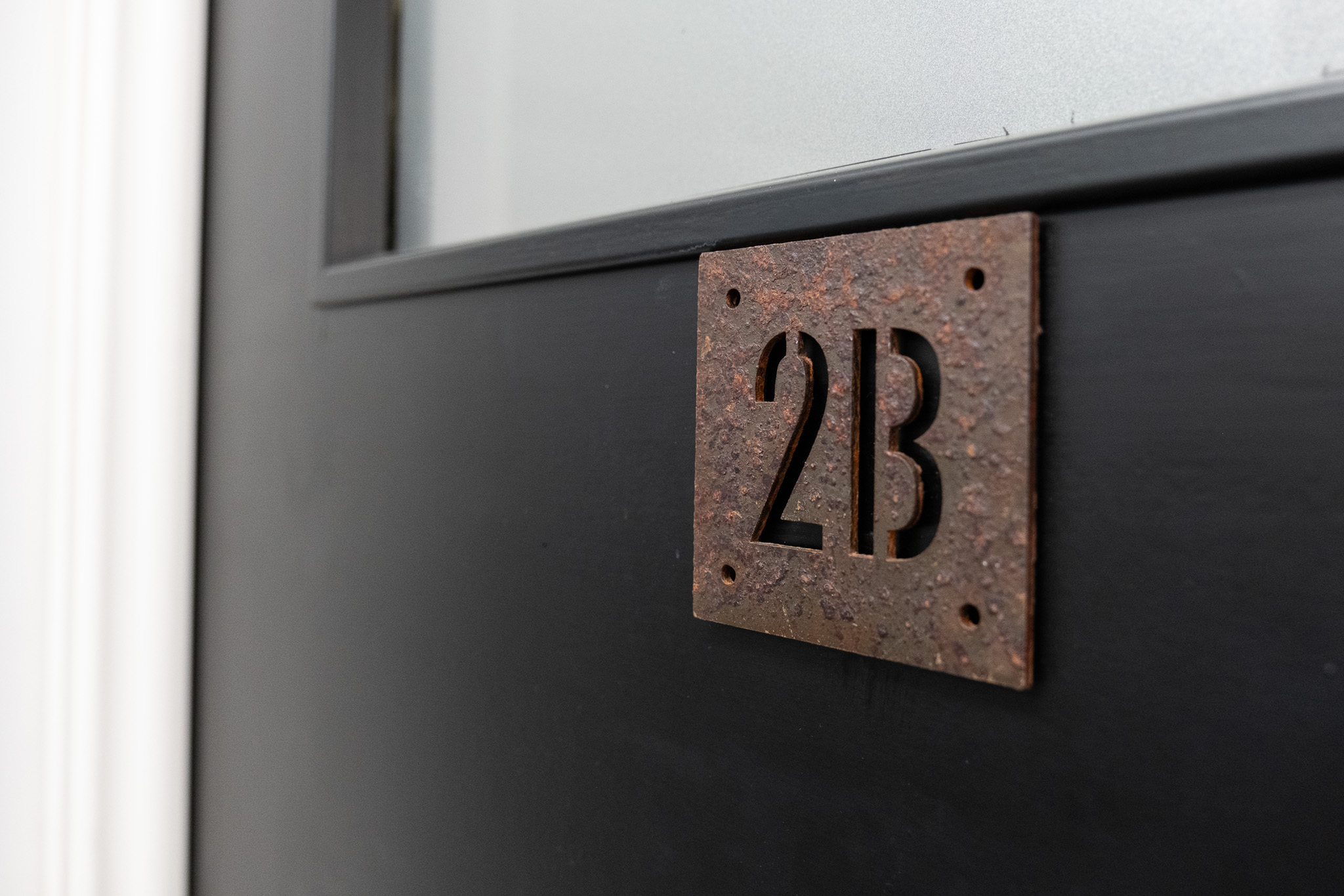 Close up on door sign number for office 2B, 3 Tannery House with corridor in background