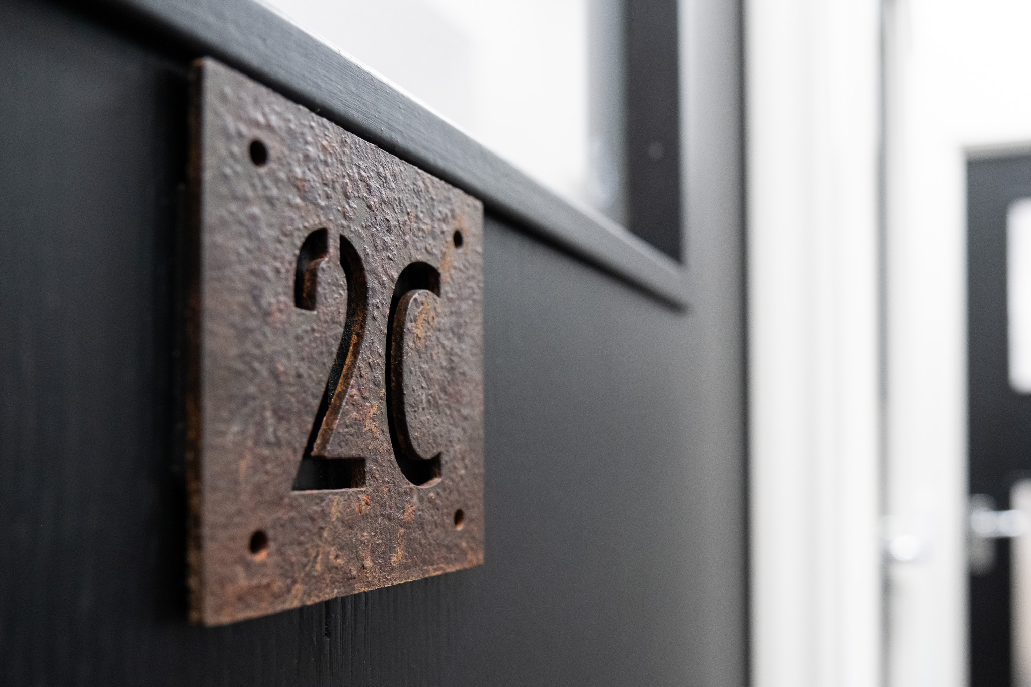 Close up on door sign number for office 2C, 3 Tannery House with corridor in background