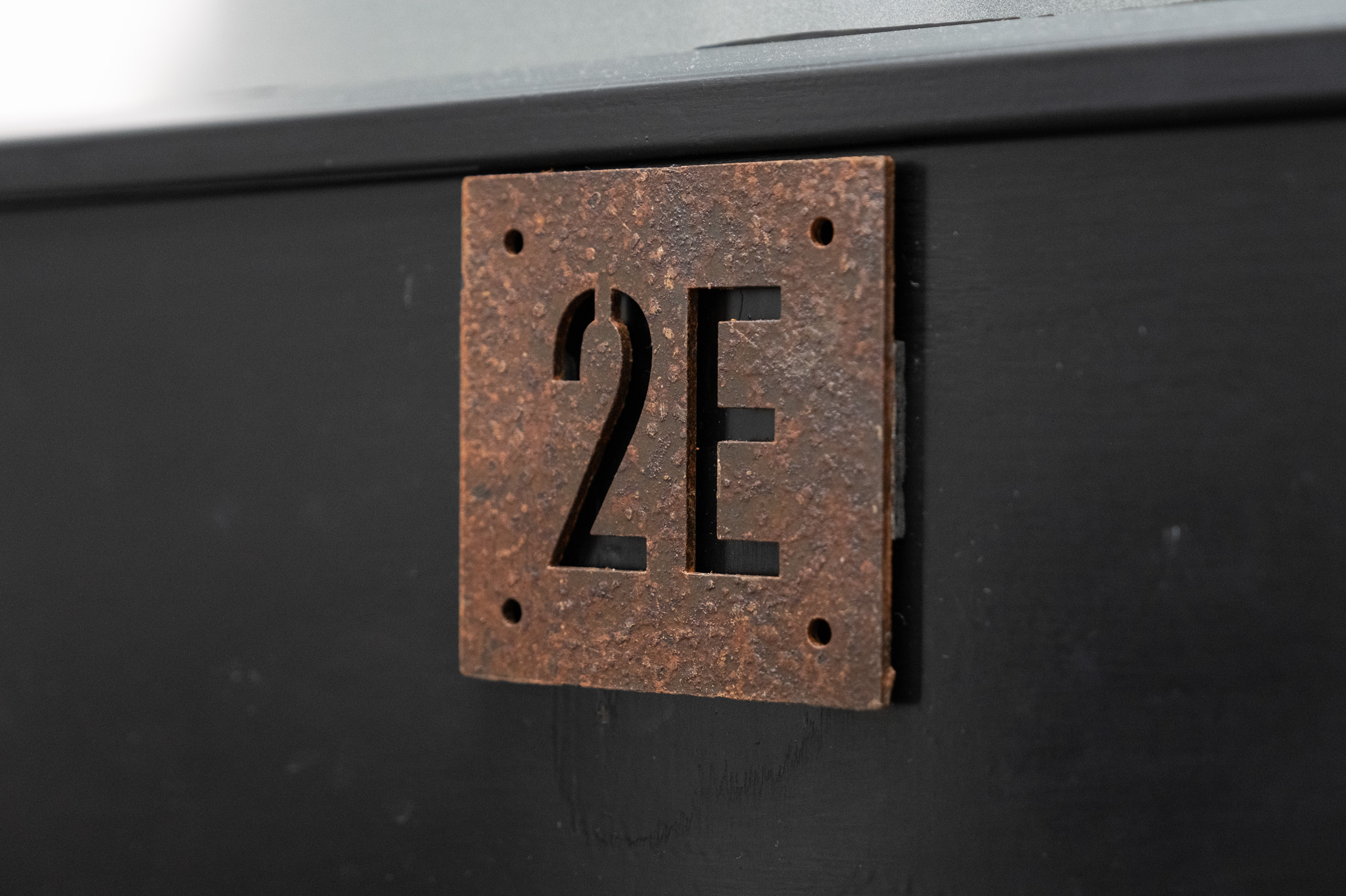 Close up on door sign number for office 2E, 3 Tannery House with corridor in background