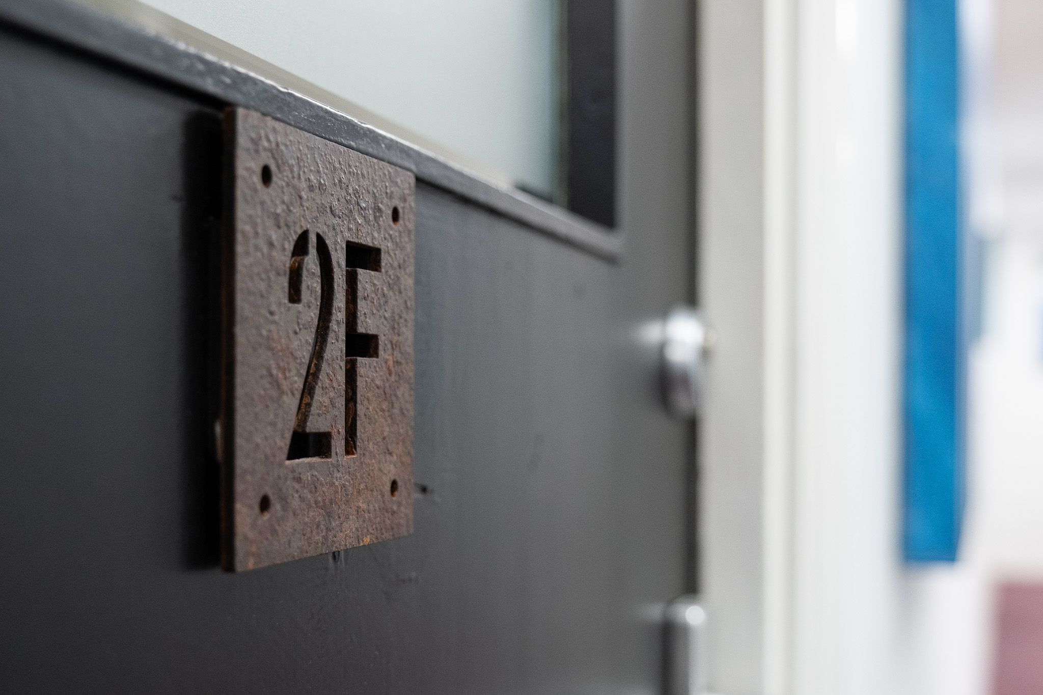 Close up on door sign number for office 2F, 3 Tannery House with corridor in background