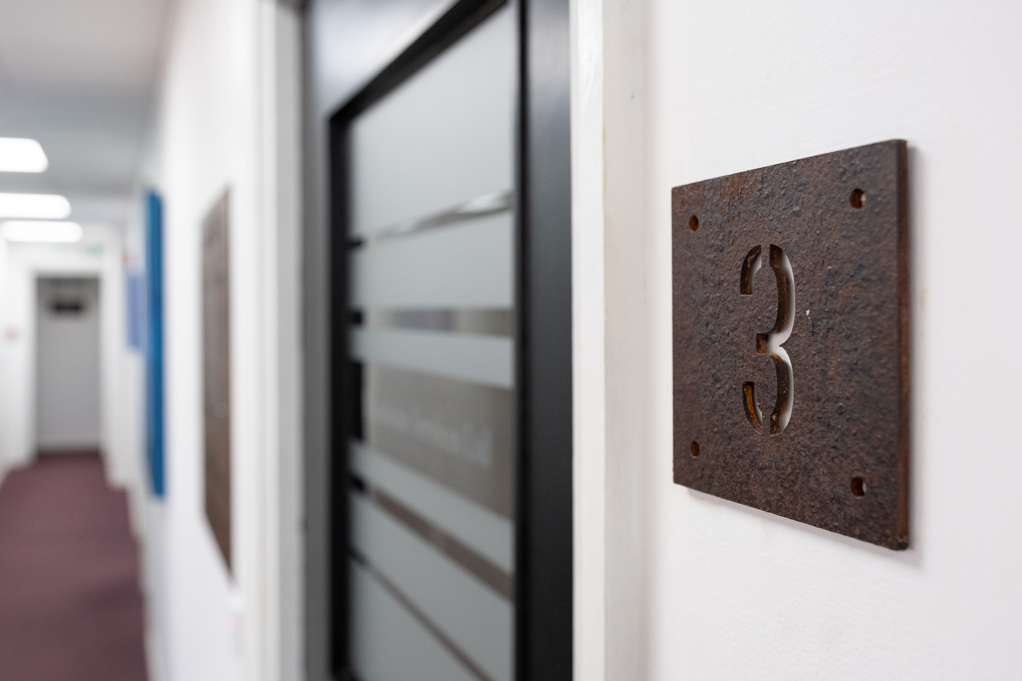 Close up on door sign number for office 3, 3 Tannery House with corridor in background