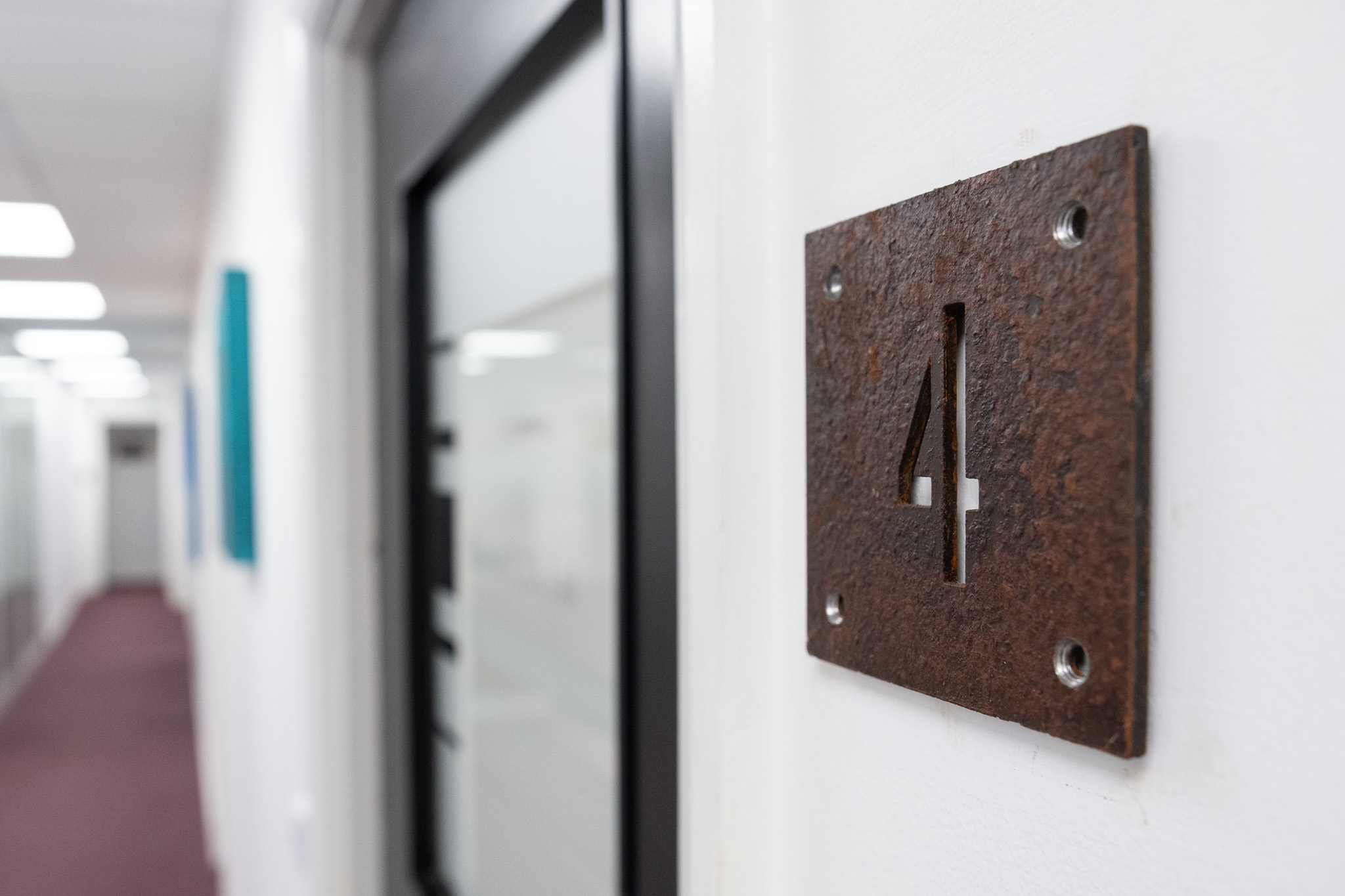 Close up on door sign number for office 4, 3 Tannery House with corridor in background