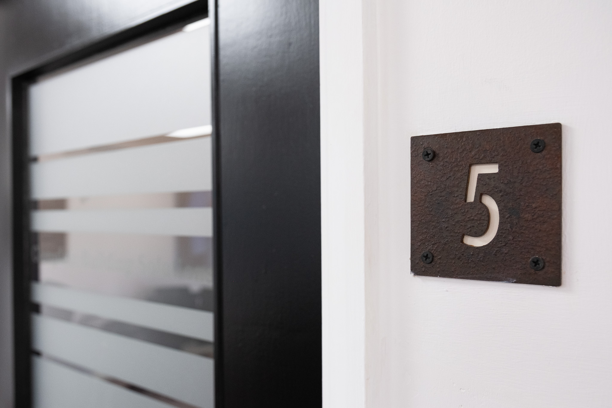 Close up on door sign number for office 5, 3 Tannery House with corridor in background