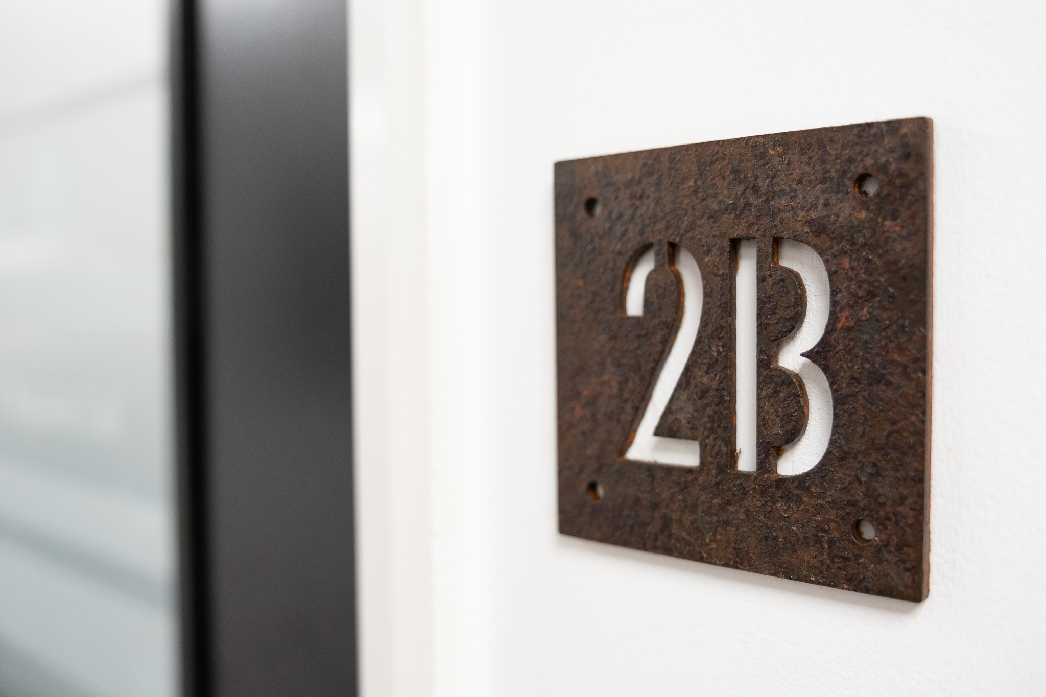 Close up on door sign number for office 2B, 4 Tannery House with corridor in background