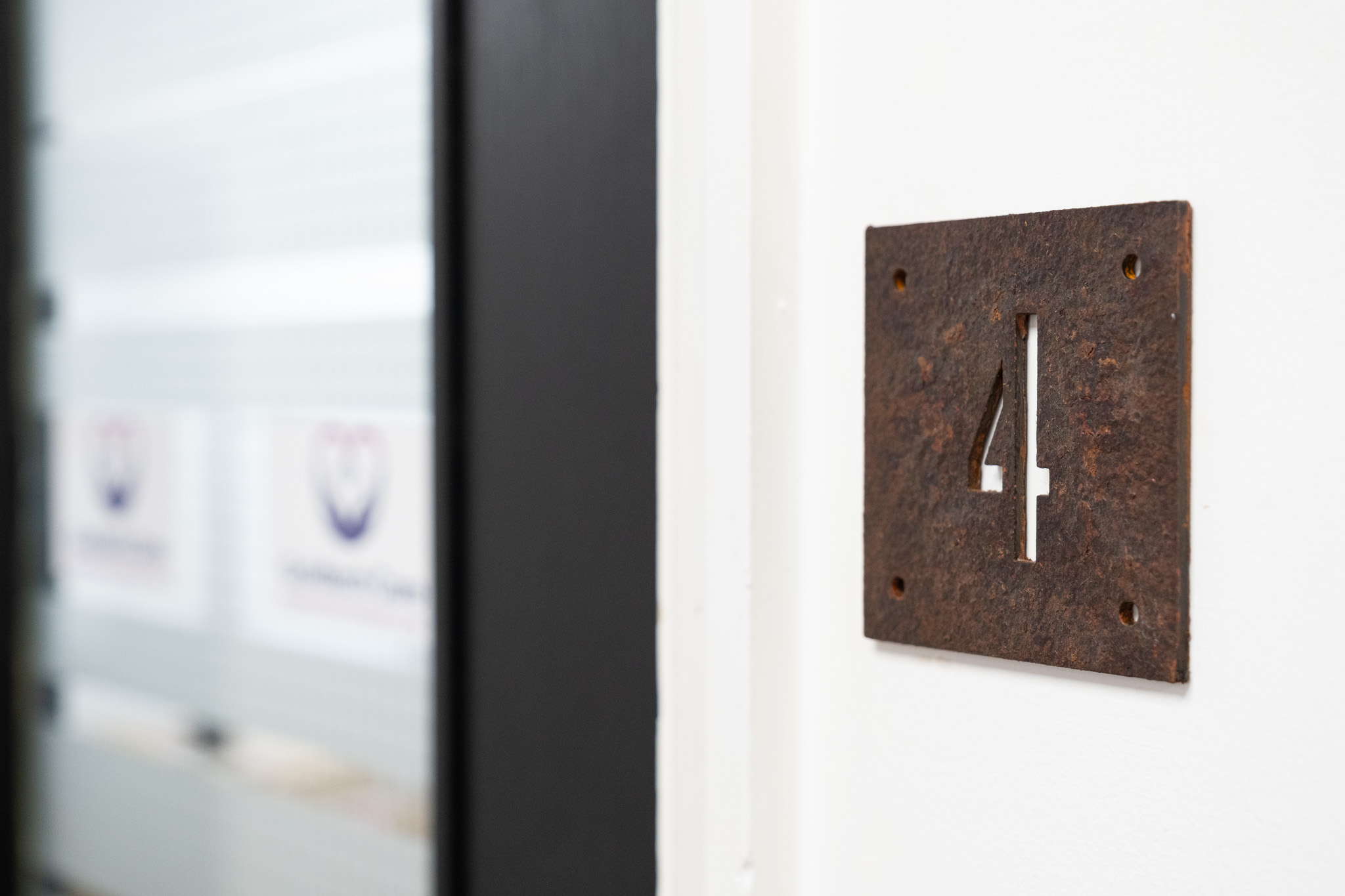 Close up on door sign number for office 4, 4 Tannery House with corridor in background